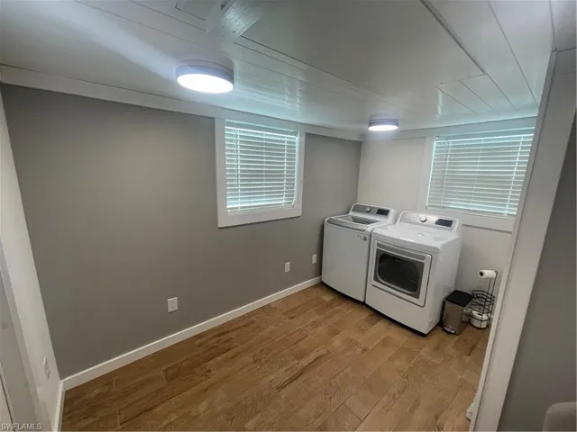 Laundry area featuring light wood-style floors and washing machine and dryer