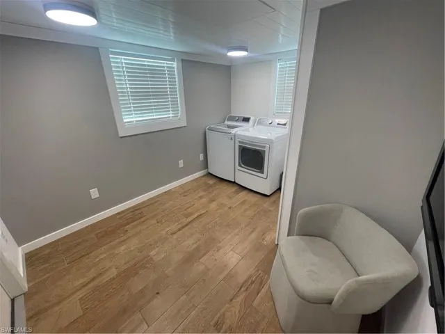 Laundry area with light wood finished floors and separate washer and dryer