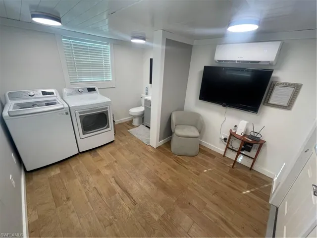 Laundry area featuring light wood finished floors and independent washer and dryer