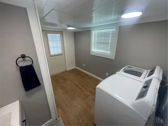 Laundry area with hardwood / wood-style flooring, separate washer and dryer, and plenty of natural light