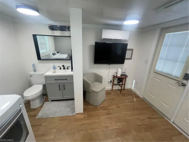 Bathroom with vanity, washer / dryer, and light wood-style floors