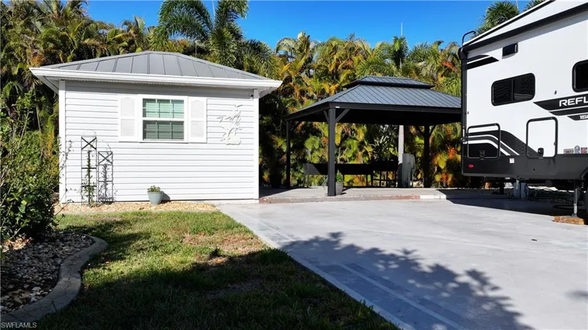 View of home's exterior featuring a gazebo, a carport, a standing seam roof, and an outdoor structure