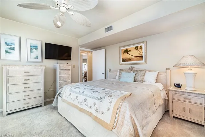 Bedroom with light colored carpet and a ceiling fan