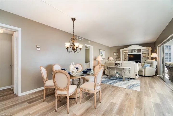 Dining space with light wood-style flooring and a chandelier