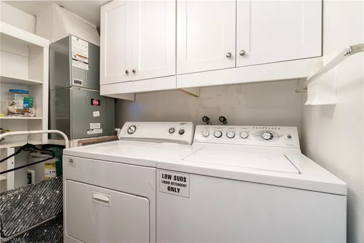 Washroom featuring cabinet space, heating unit, and independent washer and dryer