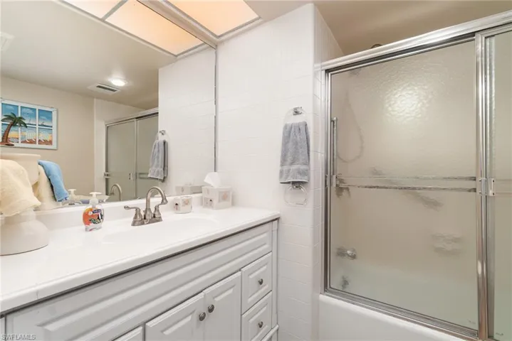 Bathroom featuring vanity and enclosed tub / shower combo