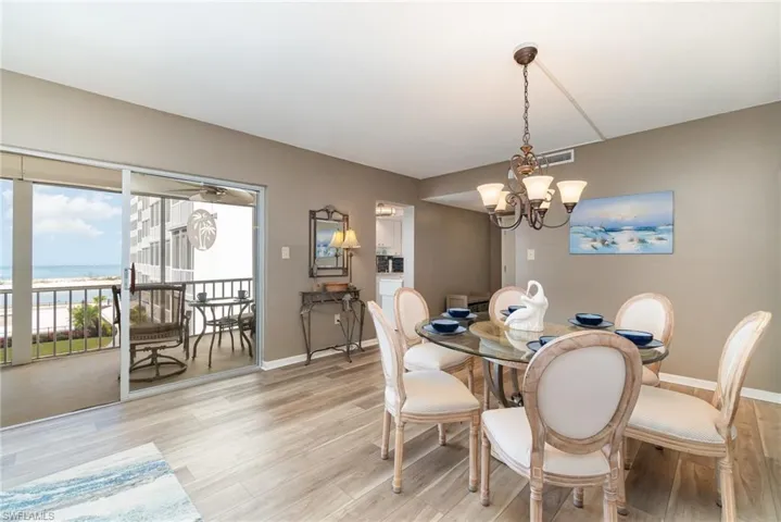 Dining room featuring light wood-style floors, a chandelier, and a water view