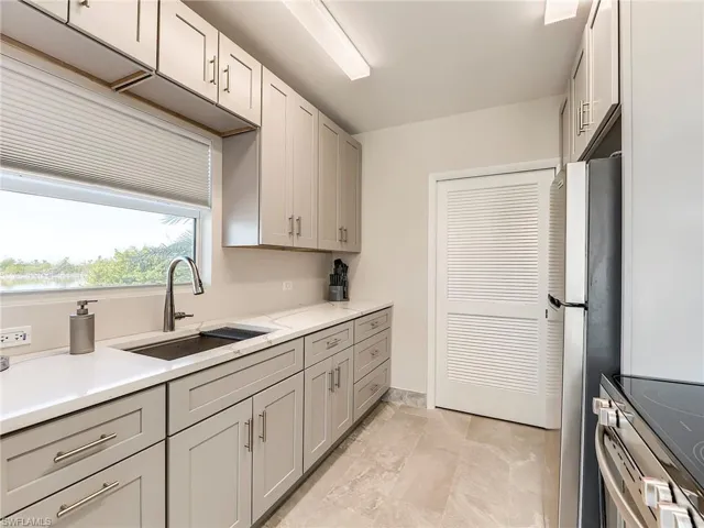 Community Kitchen featuring stainless steel appliances, gray cabinets, and light stone countertops