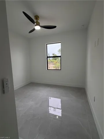 Spare room with baseboards and a ceiling fan