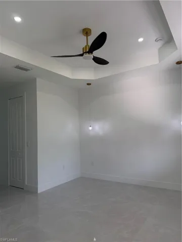 Unfurnished room featuring a tray ceiling, a ceiling fan, and recessed lighting