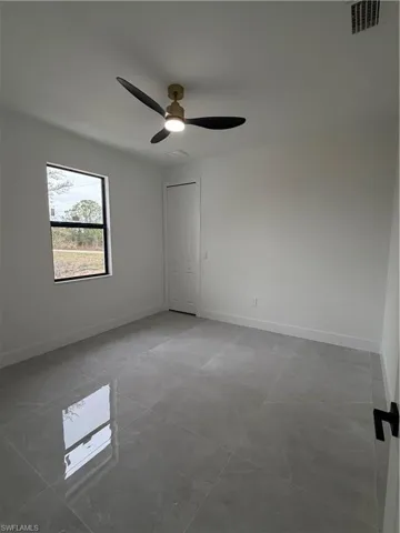 Empty room featuring baseboards and a ceiling fan