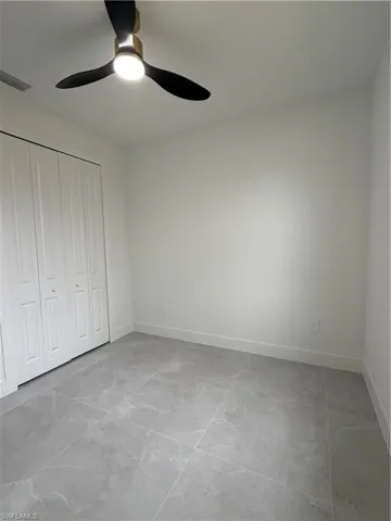 Unfurnished bedroom featuring ceiling fan and a closet