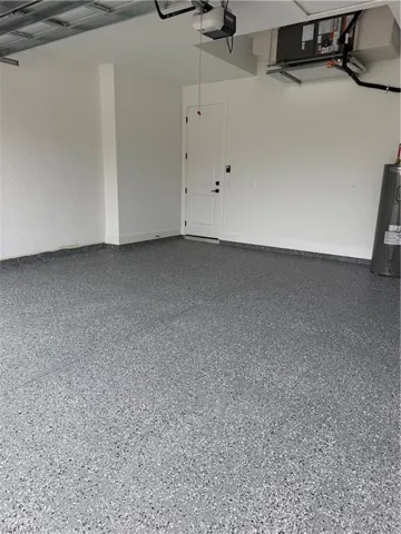 Garage featuring water heater and a garage door opener