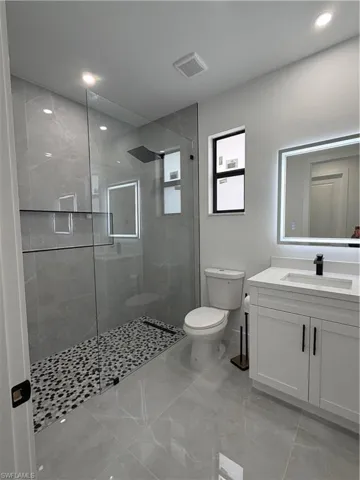 Full bath featuring vanity, walk in shower, and recessed lighting