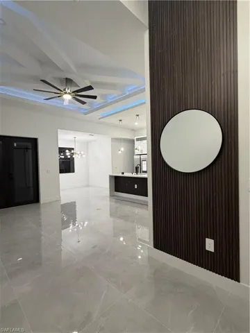 Hall with light marble finish floors and coffered ceiling