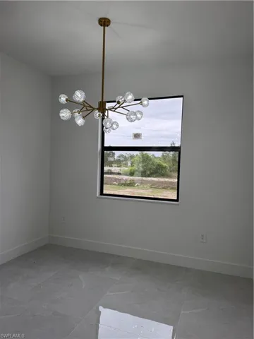 Spare room with baseboards and hanging lights