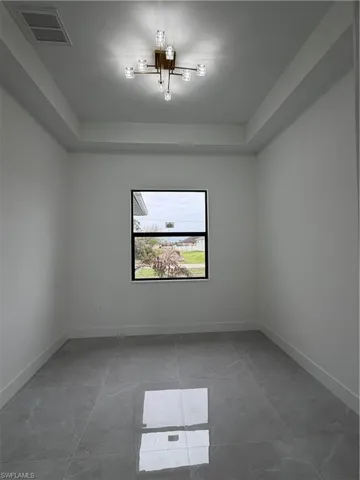 Empty room featuring a tray ceiling
