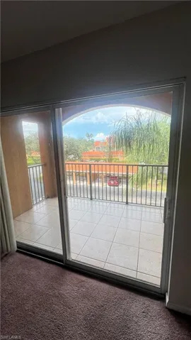 Doorway to outside with carpet and healthy amount of natural light