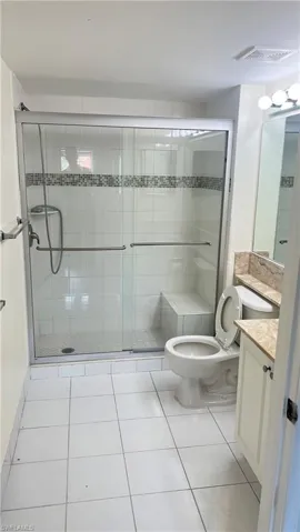 Bathroom with vanity, light tile patterned flooring, and a shower stall