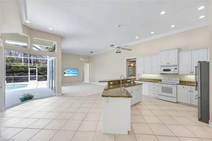 Kitchen featuring white cabinets, white appliances, a ceiling fan, crown molding, and recessed lighting
