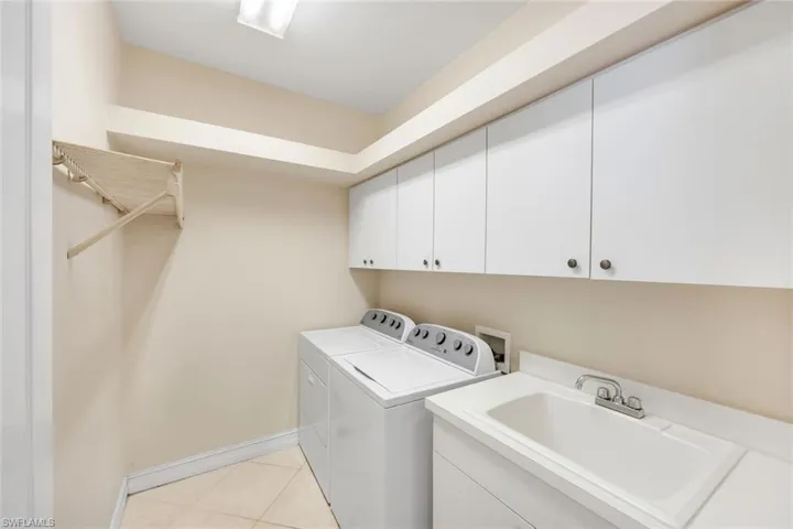 Laundry area featuring cabinets, washer, dryer and soaking tub