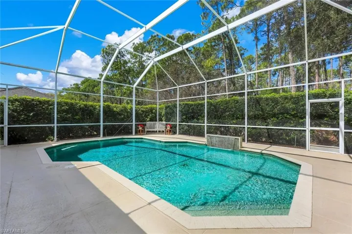 Swimming pool with glass enclosure, a sunroom, and a patio