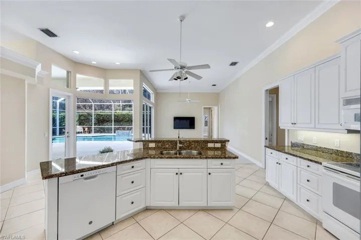 Kitchen overlooking the Family Room with a center island with white cabinetry with all the major appliances.