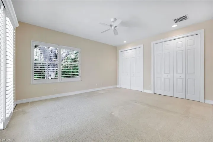 Back bedroom #5 featuring double closets and view of the preserve. Access to the pool through the Double glass sliders.