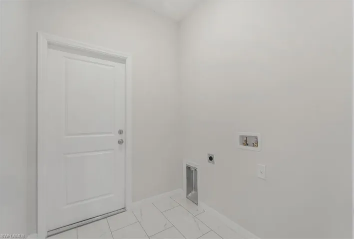 Laundry area featuring electric dryer hookup, hookup for a washing machine, and light marble finish floors
