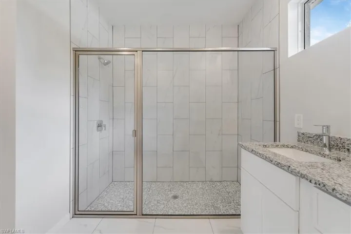Full bath featuring a shower stall and vanity