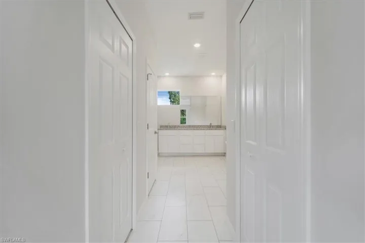 Hallway with recessed lighting and light marble finish flooring