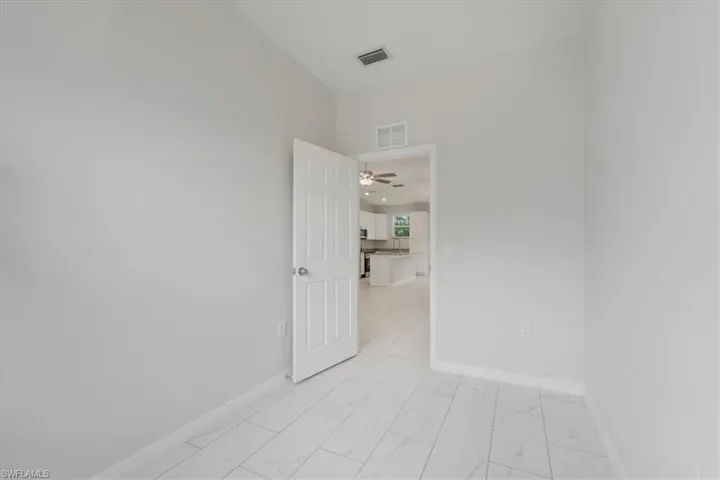 Unfurnished room with light marble finish flooring and a ceiling fan