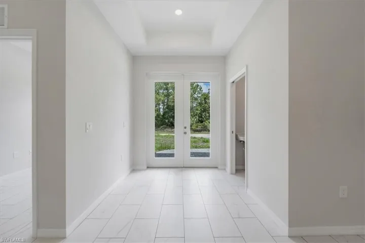 Doorway featuring french doors and a tray ceiling