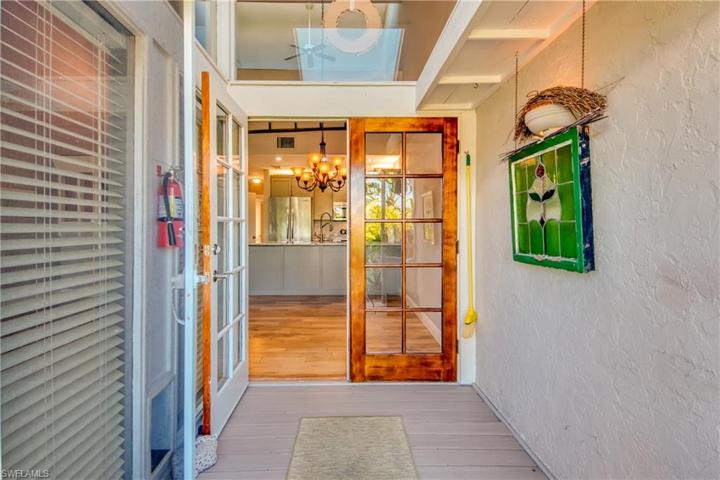 Lanai Hallway leading to outside with skylight above and double french doors
