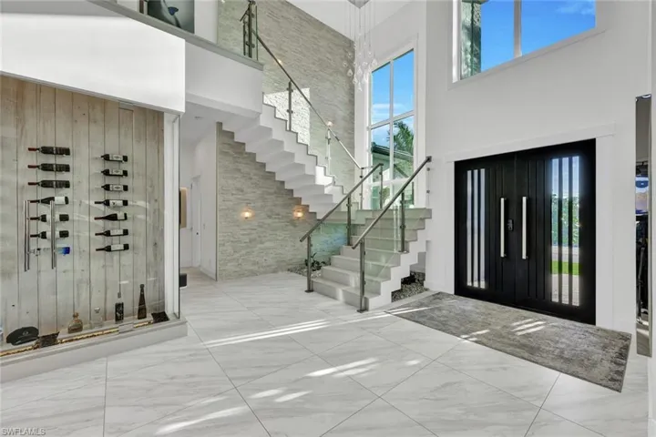 Floating staircase w/solid quartz treads & glass railings plus a custom front entry door