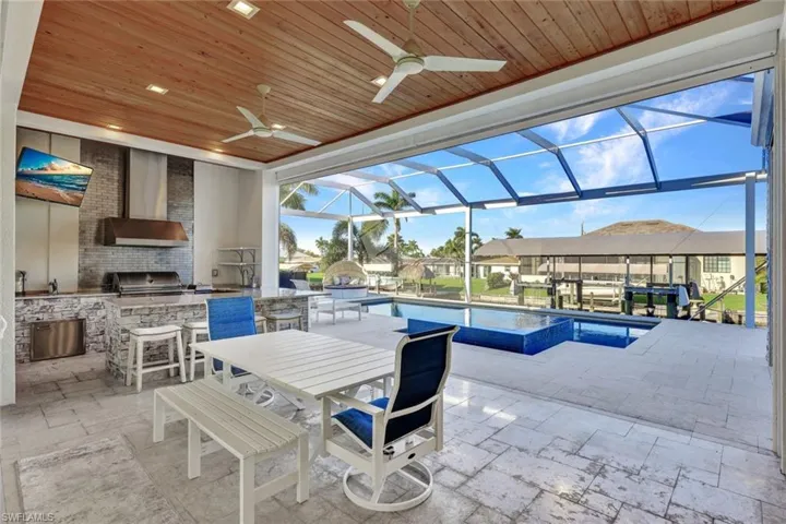 Outdoor Kitchen has a 36" grill, stainless steel cabinets, exotic level granite, ice maker/beverage cooler & tiled backsplash