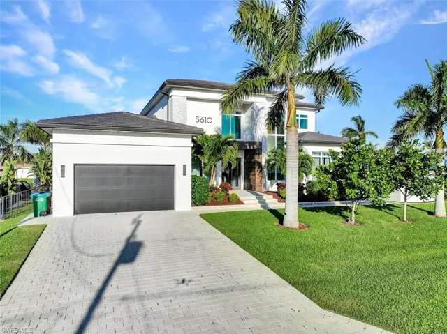 Oversized garage with brick pavered driveway and walkway