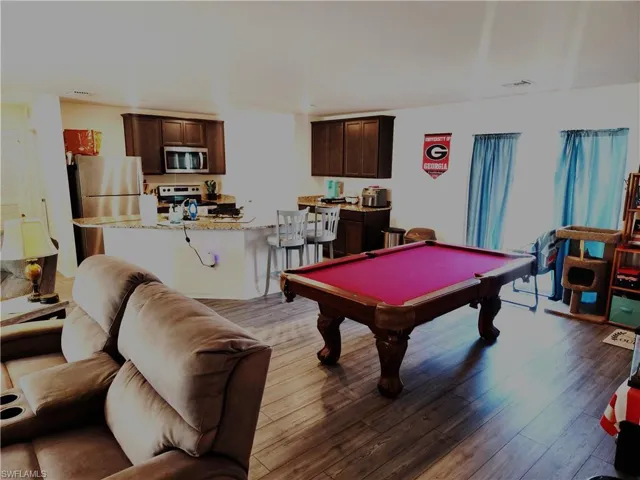 Playroom with hardwood / wood-style flooring and billiards