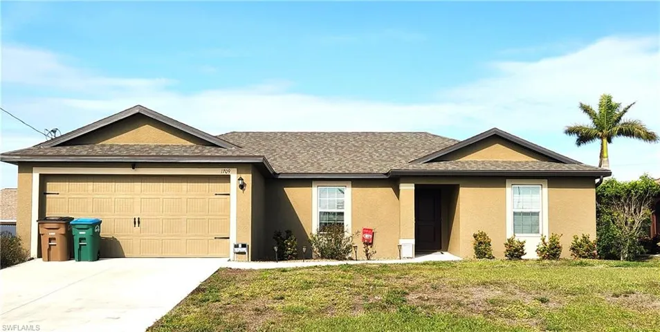 Ranch-style house with a garage and a front yard