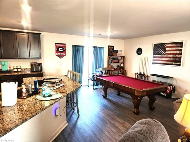 Game room with dark hardwood / wood-style floors and billiards