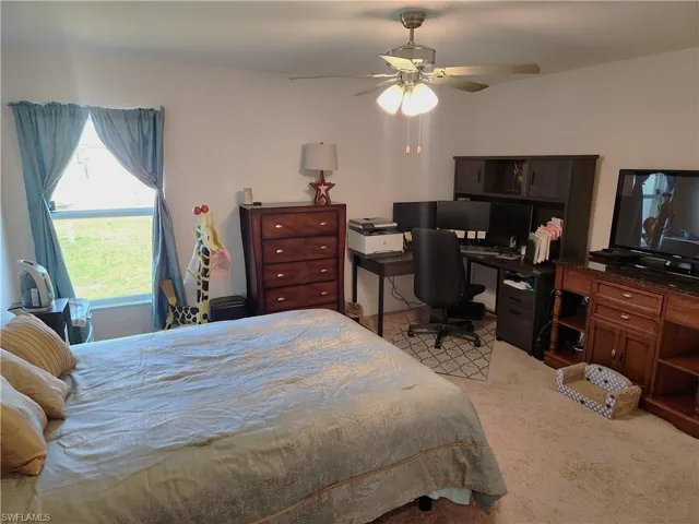 Bedroom with ceiling fan and light colored carpet