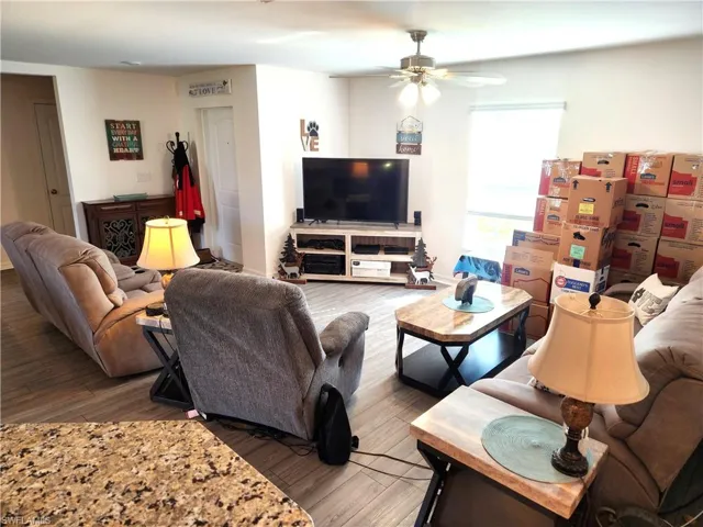 Living room featuring wood-type flooring and ceiling fan