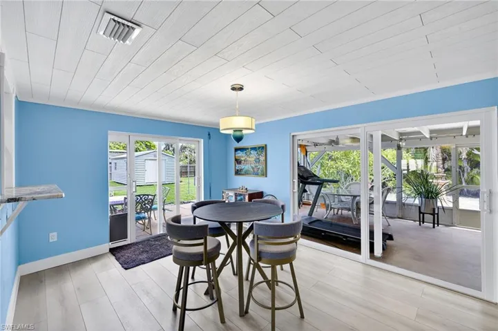Dining space with a sunroom, light wood-style floors, and wooden ceiling