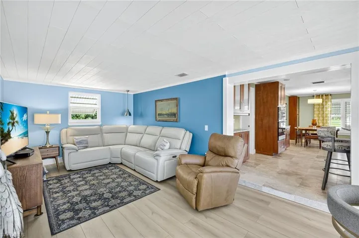Living area with light wood-type flooring and ornamental molding