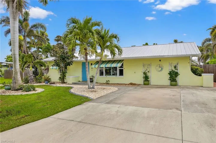 Single story home featuring stucco siding, a front yard, a metal roof, and concrete driveway