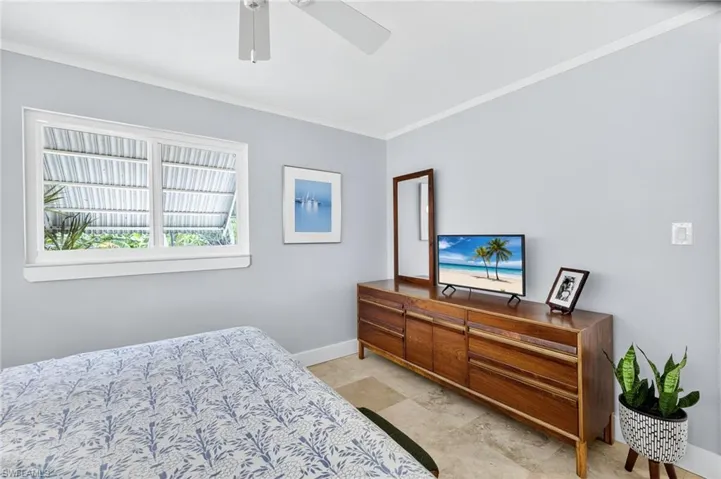 Bedroom with crown molding and ceiling fan