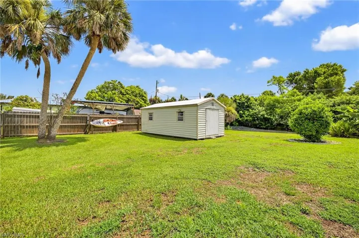 Fenced backyard with a storage shed and a patio