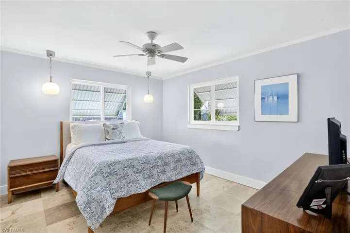 Bedroom with ornamental molding and a ceiling fan