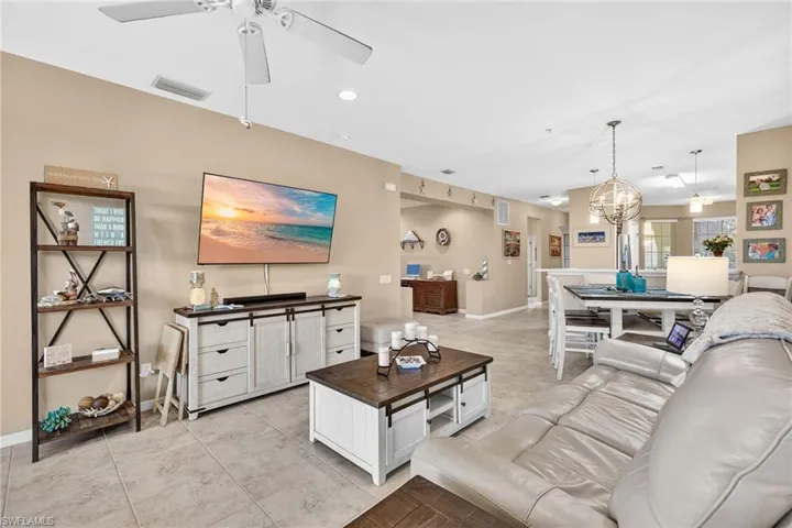 Living area with recessed lighting, a chandelier, a ceiling fan, and light tile patterned floors
