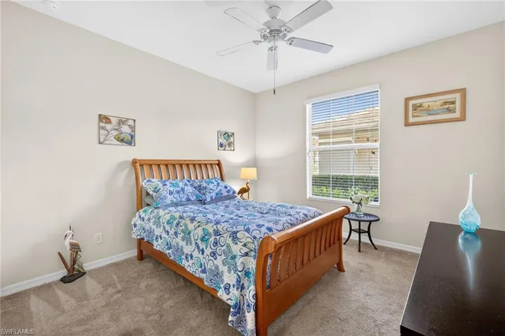 Carpeted bedroom featuring baseboards and ceiling fan